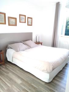 1 cama blanca grande en un dormitorio con ventana en LES RIVES DE L'ISLE, en Saint-Astier