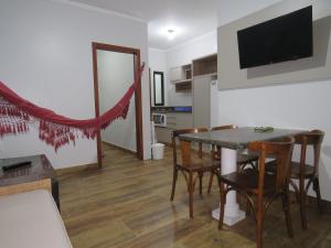 a kitchen and dining room with a table and chairs at Residencial Sol e Lua in Palhoça