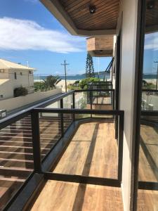 a balcony with a wooden floor and a railing at Residencial Sol e Lua in Palhoça