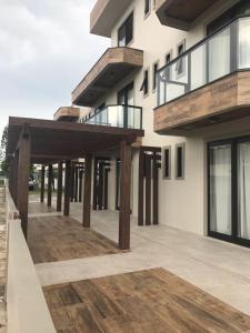 un grand bâtiment avec des poteaux en bois et une terrasse dans l'établissement Residencial Sol e Lua, à Palhoça