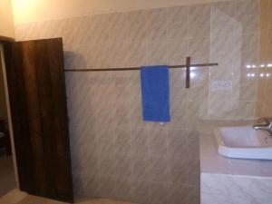 a bathroom with a blue towel on a towel rack at Mama Njoe Lodge in Kiwengwa