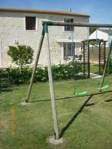 un columpio vacío en un patio en Gite à Sablonceaux pres de royan et la palmyre, en Sablonceaux