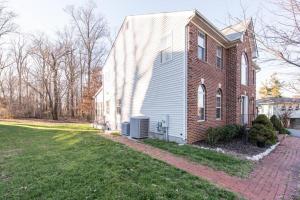 a house with a brick building and a grass yard at Superb Basement close to the Gaylord MGM Outlets National Harbor in Fort Washington