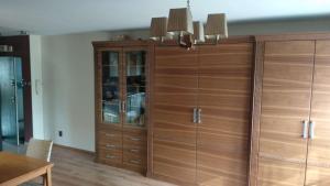 um grande armário de madeira num quarto com uma mesa em Leśny Apartament em Białystok