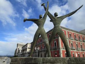 a statue of three people holding their arms up at Casa Gioia in Taranto
