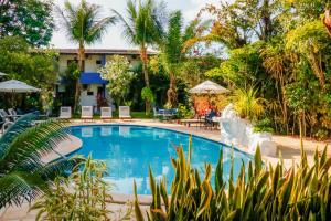una piscina in un resort con palme di Pousada Arriba Pipa a Pipa
