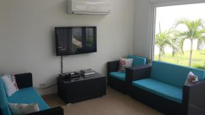 een woonkamer met 2 stoelen en een televisie bij Confortable House at Ibiza Beach Residences 2, Panamá, Río Hato in Nancito