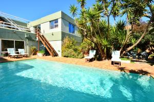 a swimming pool in front of a house at Secret Garden Guesthouse in Bloubergstrand