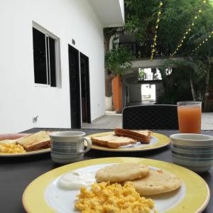 una mesa con dos platos de desayuno. en Hotel El Emigrante, en Puerto Colombia