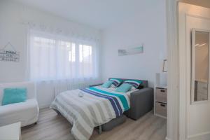 - une chambre blanche avec un lit et une chaise dans l'établissement studio marine 100m plage, à Royan