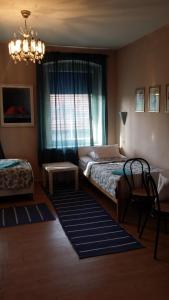 a bedroom with a bed and a window with a chandelier at Gościniec ELLA INN Lipniki in Lipniki