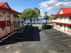 彭蒂克顿SlumberLodge Hotel的建筑前和水面上的停车场