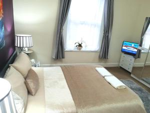a bedroom with a large bed and a window at Gabriel Guesthouse in Rhyl