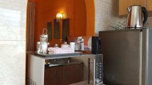 a kitchen with a microwave and a refrigerator at Lolo's 1bed Apt-Best location-2Balconies in Harare