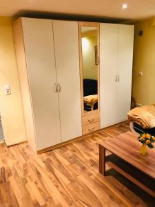 ein Schlafzimmer mit weißen Schränken und einem Spiegel in der Unterkunft Idyllische und ruhig gelegene 1ZKB Wohnung in Ludwigshafen am Rhein in Ludwigshafen am Rhein