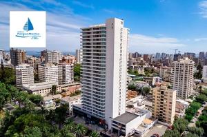 un edificio alto y blanco en medio de una ciudad en Departamento Central Uno Norte Viña del Mar, en Viña del Mar