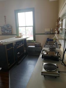 a kitchen with a stove top with a window at Golden Cross Hotel in Waihi