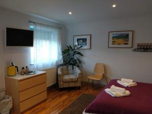 a bedroom with a bed and a tv on the wall at B - Simply Rooms in Stow on the Wold