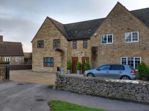 a car parked in front of a stone house at B - Simply Rooms in Stow on the Wold