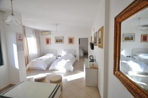 a room with three beds with a mirror at Aparthotel Shkodra in Durrës