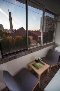 une chambre avec deux chaises, une table et une fenêtre dans l'établissement Studio Apartment Petrzalka Air-Conditioned 24h check-in, à Bratislava