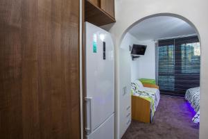 a room with a white refrigerator and a bedroom at Studio Apartment Petrzalka Air-Conditioned 24h check-in in Bratislava