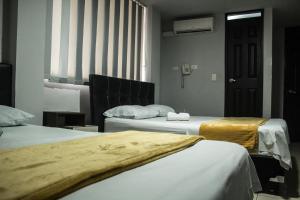 Postel nebo postele na pokoji v ubytování Hotel Escorial Ibagué