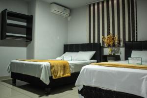 Postel nebo postele na pokoji v ubytování Hotel Escorial Ibagué