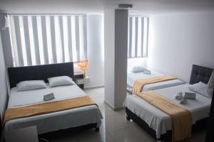 Postel nebo postele na pokoji v ubytování Hotel Escorial Ibagué