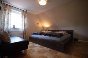 una camera da letto con un letto grande e una finestra di Ferienhaus an der Iller a Aitrach