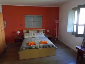 1 dormitorio con 1 cama grande y paredes de color naranja en La casona Segunda Usina en Embalse
