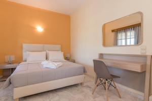 a bedroom with a bed and a desk and a mirror at Villa Fos in Gaïtánion