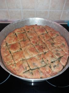 a large pizza in a pan on a stove at Kynthia Guesthouse in Neochori