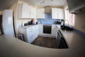 a kitchen with white cabinets and a counter top at Baystays Scenic View in Swansea