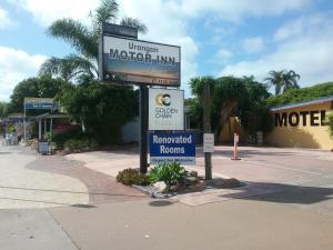 a sign for a motor inn on the side of a street at Urangan Motor Inn in Hervey Bay