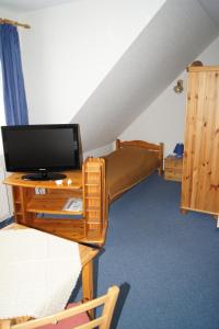 a room with a bunk bed and a tv on a table at Hotel Dorfkrug Büsum in Büsum