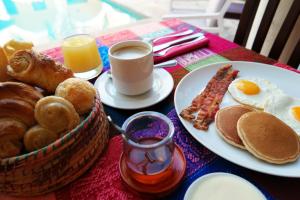 a table topped with plates of breakfast foods and drinks at Merida Santiago Hotel Boutique in Mérida