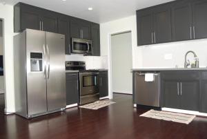 a kitchen with stainless steel appliances and black cabinets at Silicon Valley Stays Casa Tres in Mountain View