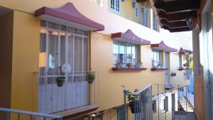 une rangée de balcons dans un bâtiment avec des plantes en pot dans l'établissement Posada Antiguo Camino Real, à Xalapa