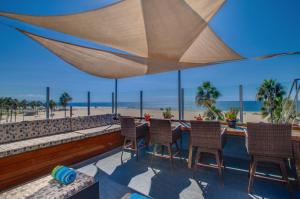 a patio with chairs and a table with a view of the beach at Venice Breeze Suites in Los Angeles