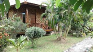 a house with a wooden porch in a garden at Ban Ban Bangalow in Ko Jum