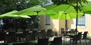 a group of tables and chairs with green umbrellas at Hotel-Restaurant Moser Pöchlarn in Pöchlarn