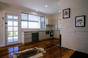 a kitchen with a large window and a brick wall at Leichhardt Cottages in Relbia