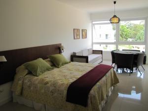 a bedroom with a bed and a table and chairs at Green Park Apartamentos in Punta del Este