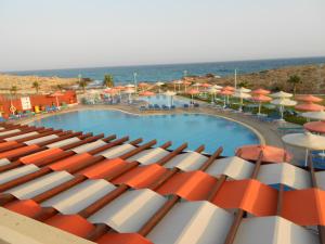 a view of a swimming pool with umbrellas and the ocean at Aktea Beach Village in Ayia Napa