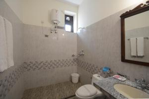 a bathroom with a toilet and a sink and a mirror at Moti Mahal - A Heritage Haveli in Pushkar