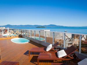 uma varanda com duas cadeiras e uma piscina num navio de cruzeiro em Al Mare Hotel em Florianópolis