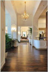 バート・キッシンゲンにあるBRISTOL Hotel Bad Kissingenのシャンデリアと廊下が備わる広い客室です。