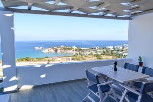 a table and chairs on a balcony with a view of the ocean at Alsalos Villas in Amoopi