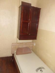 um pequeno quarto com uma cama e um armário em Hospedagem Ledo no Rio de Janeiro